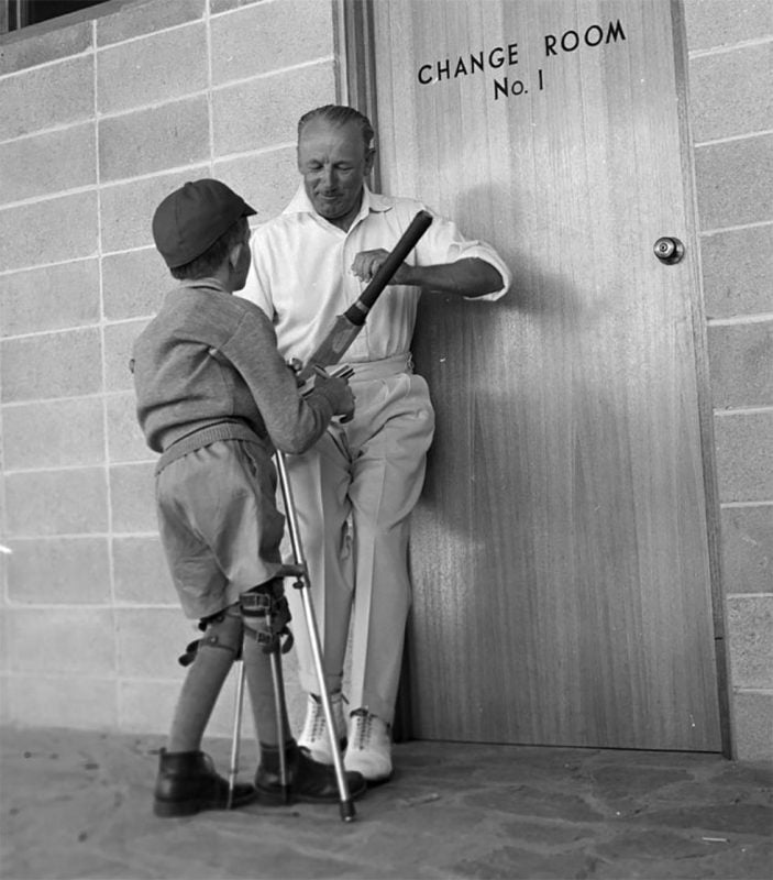 1963 Don Bradman signs 9yr old cricket bat. Credit NAA